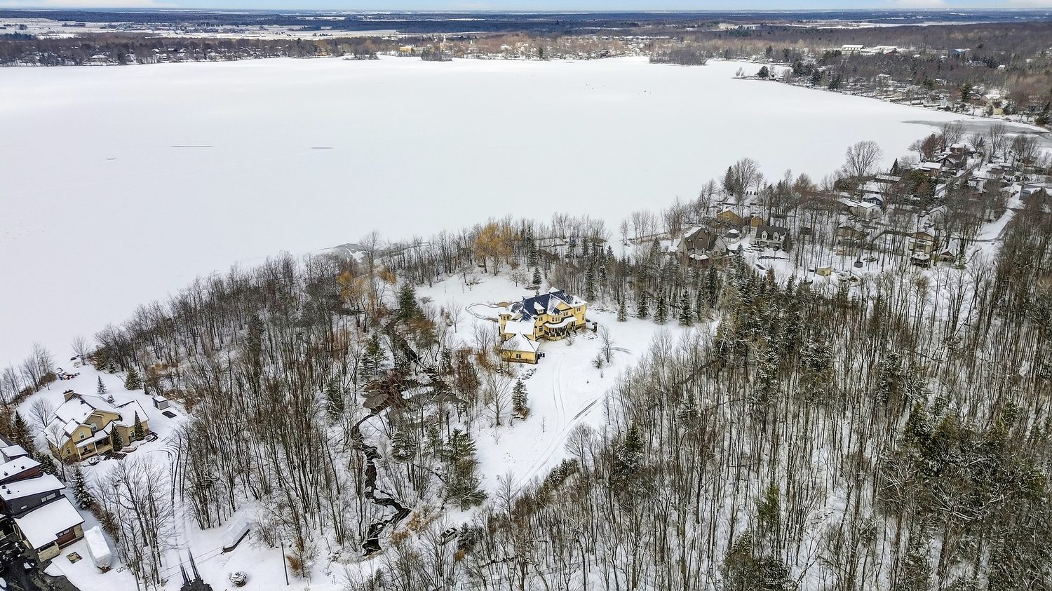 Vue aérienne d'une propriété au bord d'un lac gelé